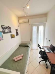 Zimmer mit einem Bett und einem Schreibtisch mit einem Laptop in der Unterkunft Apartment in Santa Marinella in Santa Marinella