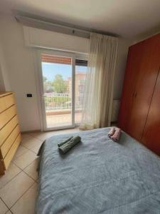 ein Schlafzimmer mit einem Bett und einem großen Fenster in der Unterkunft Apartment in Santa Marinella in Santa Marinella