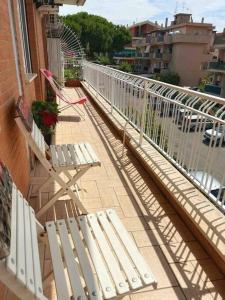 2 weiße Stühle auf einem Balkon mit Geländer in der Unterkunft Apartment in Santa Marinella in Santa Marinella