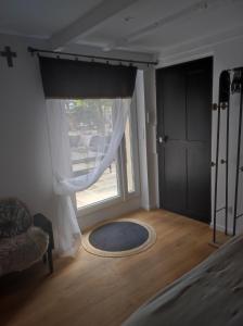 a room with a window with a rug and a door at mas de manon in Valréas