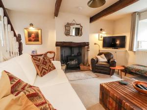 a living room with a white couch and a fireplace at 17th Century 2-bed/bath period cottage in Barrowford