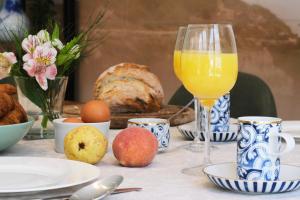 a table with a glass of orange juice and bread at Comfortable Town House in Quiet Area by LovelyStay in Lisbon