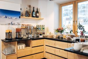 a kitchen with a counter with bottles of wine at Hotel Bambi Am Park in Solda