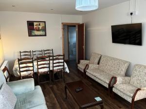 a living room with two couches and a table at Spacious 5 double bed bedroom bungalow near Belfast in Lisburn