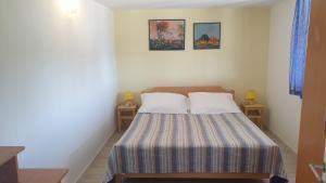 ein Schlafzimmer mit einem Bett mit zwei Kissen darauf in der Unterkunft TAKOMA in Čunski
