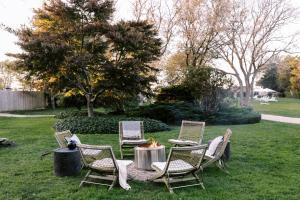 a group of chairs and a table in the grass at The Roundtree, Amagansett in Amagansett