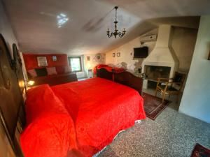 una camera con letto rosso e camino di Podere BARBI a Baschi