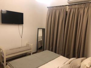 1 dormitorio con 1 cama y TV en la pared en Departamento Confortable en Corrientes Capital en Corrientes