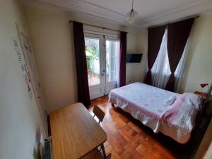 1 dormitorio con cama, mesa y ventana en RESIDENCIAL METRO REPUBLICA, en Santiago