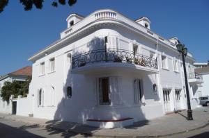 - un bâtiment blanc avec un balcon dans une rue dans l'établissement RESIDENCIAL METRO REPUBLICA, à Santiago