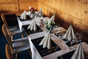 una mesa larga con servilletas blancas y copas de vino en Hotel Bambi Am Park, en Solda