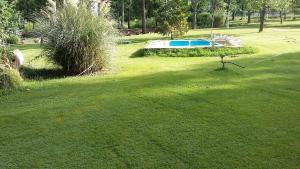 a green yard with a pool in the distance at Cabaña en Alta Montaña - Complejo Cabañas del Pastizal - USPALLATA, MENDOZA in Uspallata
