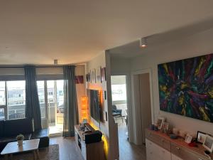 una sala de estar con una gran pintura en la pared en Eskivellir 11, en Hafnarfjördur