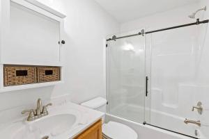 bagno bianco con doccia e lavandino di Stylist East Hampton Home a East Hampton
