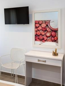 un escritorio blanco con una silla y una foto en la pared en Studio central Potos, en Potos