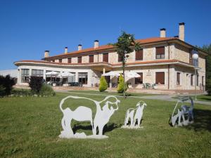 un edificio con una estatua de cabras en el césped en Prado de las merinas, en Caleruega