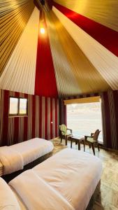 Disah的住宿－Lulua luxury camp，一间卧室设有两张床,拥有红色和黄色的天花板