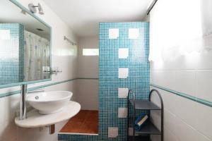 ein Bad mit einem Waschbecken und einer Glasdusche in der Unterkunft Acogedora casa p/3 c/parking a 5 min de la playa in Nigrán