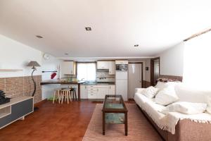ein Wohnzimmer mit einem Sofa und einem Tisch in der Unterkunft Acogedora casa p/3 c/parking a 5 min de la playa in Nigrán