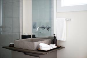 bagno con lavandino, asciugamani e specchio di The Roundtree, Amagansett ad Amagansett