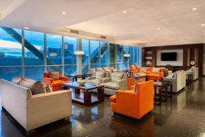 a lobby with couches and chairs and a television at Four Points By Sheraton Los Angeles in Los Ángeles