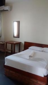 a bedroom with a large bed and a table at Hotel Alvorada in Goiânia