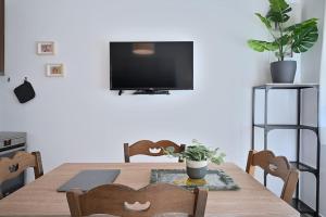 mesa de comedor con TV en la pared en Seabreeze apartment in Palaio Faliro/ Netflix, en Atenas