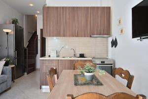 cocina con mesa de madera con sillas y fregadero en Seabreeze apartment in Palaio Faliro/ Netflix, en Atenas