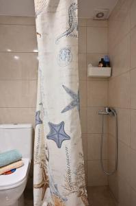 y baño con cortina de ducha y aseo. en Seabreeze apartment in Palaio Faliro/ Netflix, en Atenas