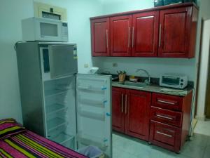 a kitchen with red cabinets and a refrigerator at Rania Chalet -Stella Di Mare Sea view- Families in Ain Sokhna