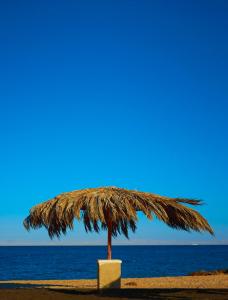 a straw umbrella on the beach at Rania Chalet -Stella Di Mare Sea view- Families in Ain Sokhna