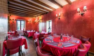 um restaurante com paredes vermelhas e mesas e cadeiras vermelhas em Appartement d'une chambre avec jardin clos et wifi a Fauverney em Fauverney