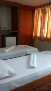 two beds sitting next to each other in a room at Hotel Alvorada in Goiânia