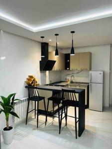a kitchen with a black table and chairs and a sink at Appartement cosy à l'Aouina in Tunis