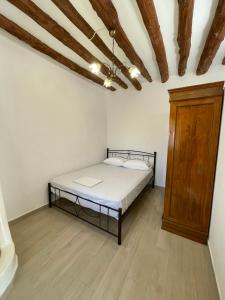 a bedroom with a bed and a wooden cabinet at Aloni Farmhouse in Karistos