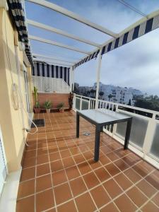 a balcony with a table on a roof at CarihuelaCity in Torremolinos