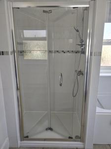 W łazience znajduje się prysznic ze szklanymi drzwiami. w obiekcie Abbey Sands Hotel w mieście Torquay