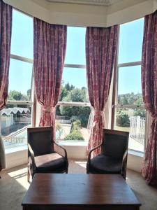 twee stoelen en een tafel voor een raam bij Abbey Sands Hotel in Torquay