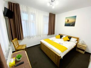 a bedroom with a bed with yellow and white sheets at Central Park House in Cluj-Napoca