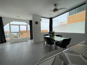 a dining room with a glass table and chairs at Sunset Terrace Ocean View in Adeje