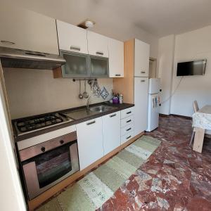 uma cozinha com armários brancos, um lavatório e um frigorífico em Sole e mare em Guardavalle