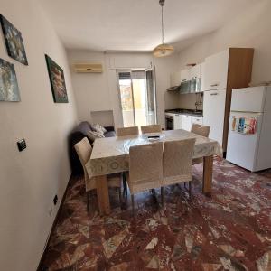 uma cozinha com mesa e cadeiras num quarto em Sole e mare em Guardavalle