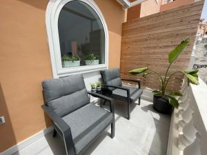 a patio with two chairs and a table and a window at Sunset Terrace Ocean View in Adeje
