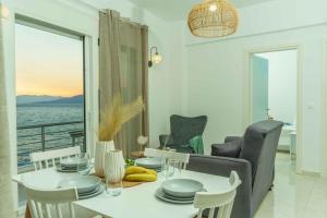 a dining room with a table and a view of the ocean at Cocoscape Suite, seaside & 270° open view in Kalamaki Heraklion