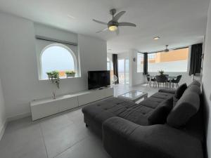 a living room with a couch and a tv at Sunset Terrace Ocean View in Adeje