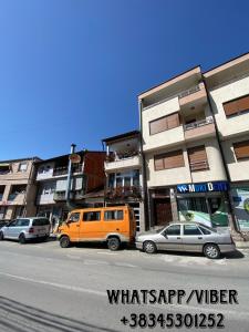eine Gruppe von Autos, die vor einem Gebäude geparkt sind in der Unterkunft Ralin Apart in Prizren