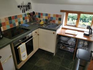 a small kitchen with a sink and a dishwasher at The Sanctuary at Boningale Manor in Wolverhampton