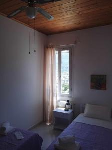 MesariáにあるAndros Lighthouse Apartmentsのベッドルーム1室(ベッド2台、窓付)
