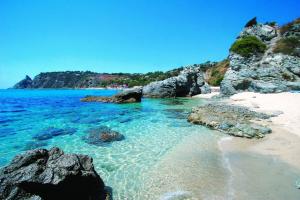 a beach with rocks and the ocean on a clear day at Hotel Santa Chiara in Capo Vaticano
