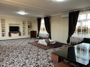 uma grande sala de estar com cortinas e uma televisão em Major Hotel em Fergana